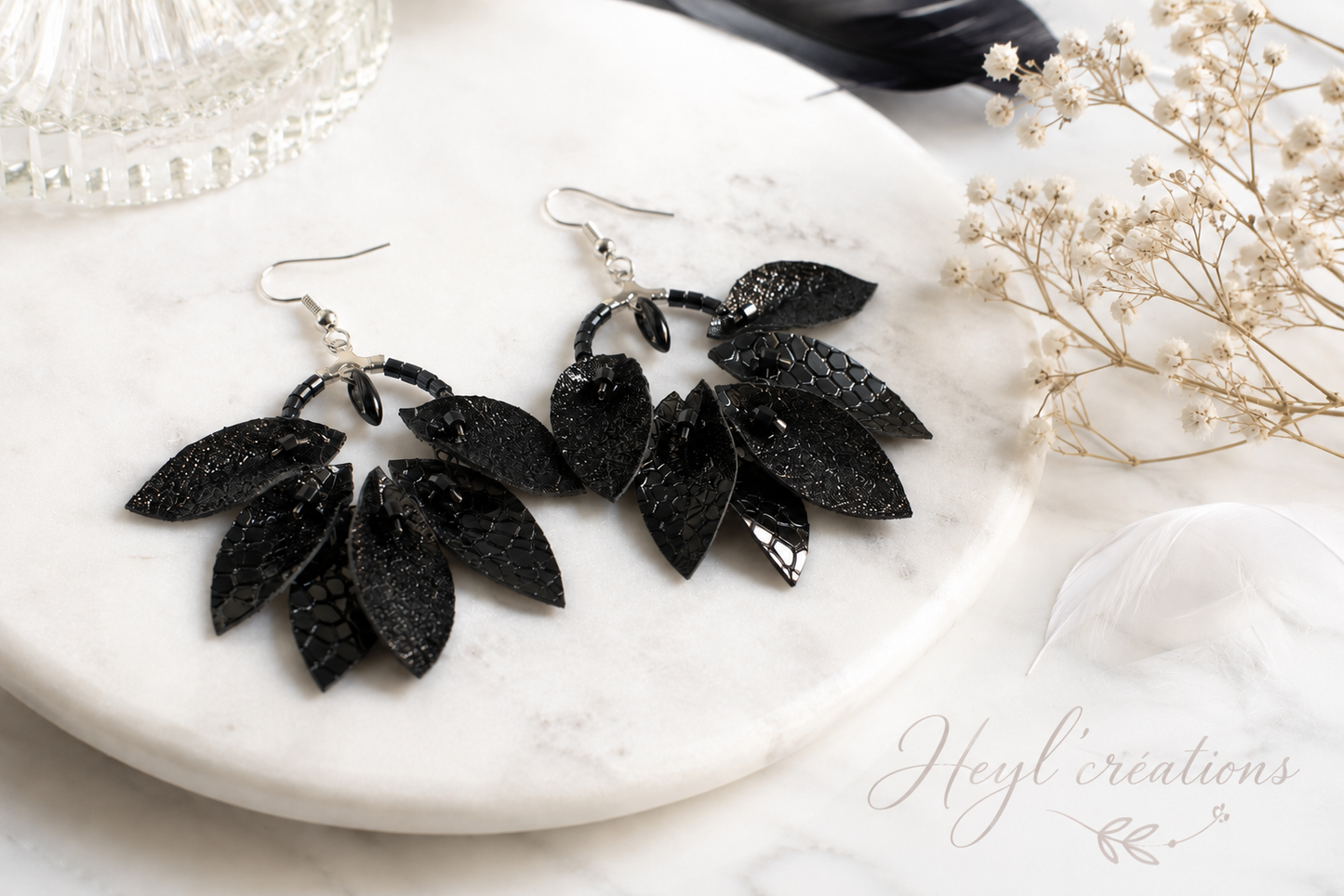 Boucles d'oreilles artisanales noires en simili cuir pailleté et perles de verre, design floral à 9 pétales, création fait main Heyl'Créations.