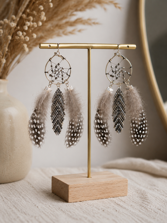 Boucles d'oreilles attrape-rêves artisanales en perles Miyuki argentées et plumes naturelles taupe dans un style bohème chic.