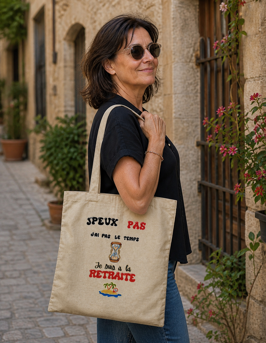 Tote bag retraite porté à l’épaule par une femme, sac coton avec message humoristique