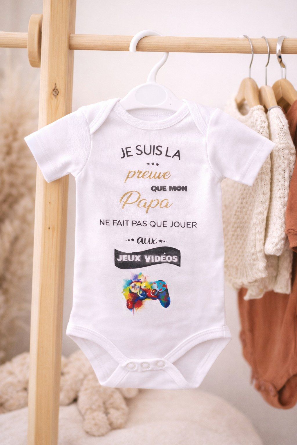 Body bébé blanc avec inscription humoristique sur un portant
