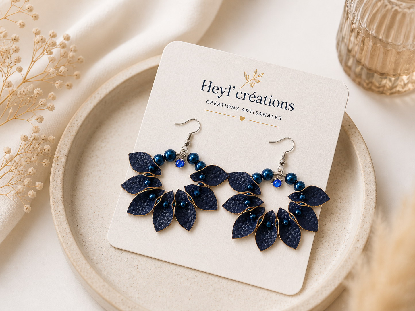 Boucles d’oreilles en simili cuir bleu avec perles posées sur carte de marque Heyl’créations