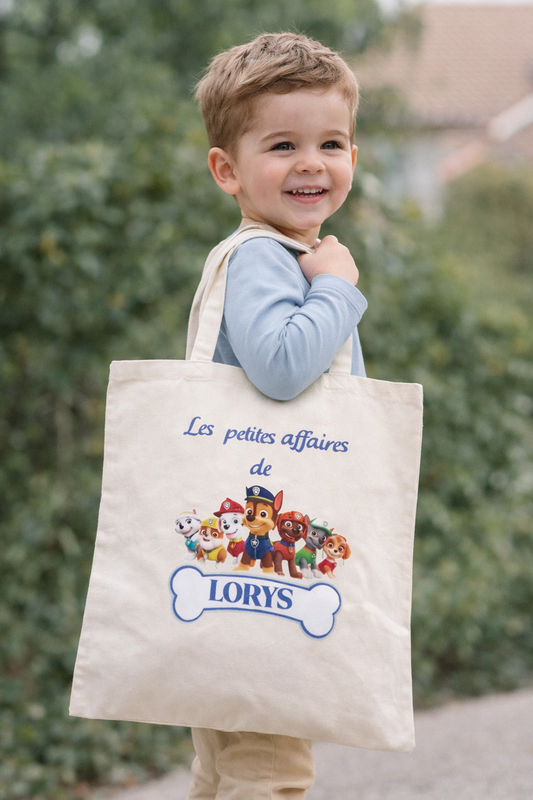 Enfant portant un tote bag personnalisé avec prénom et motif dessin animé, sac école enfant en toile coton