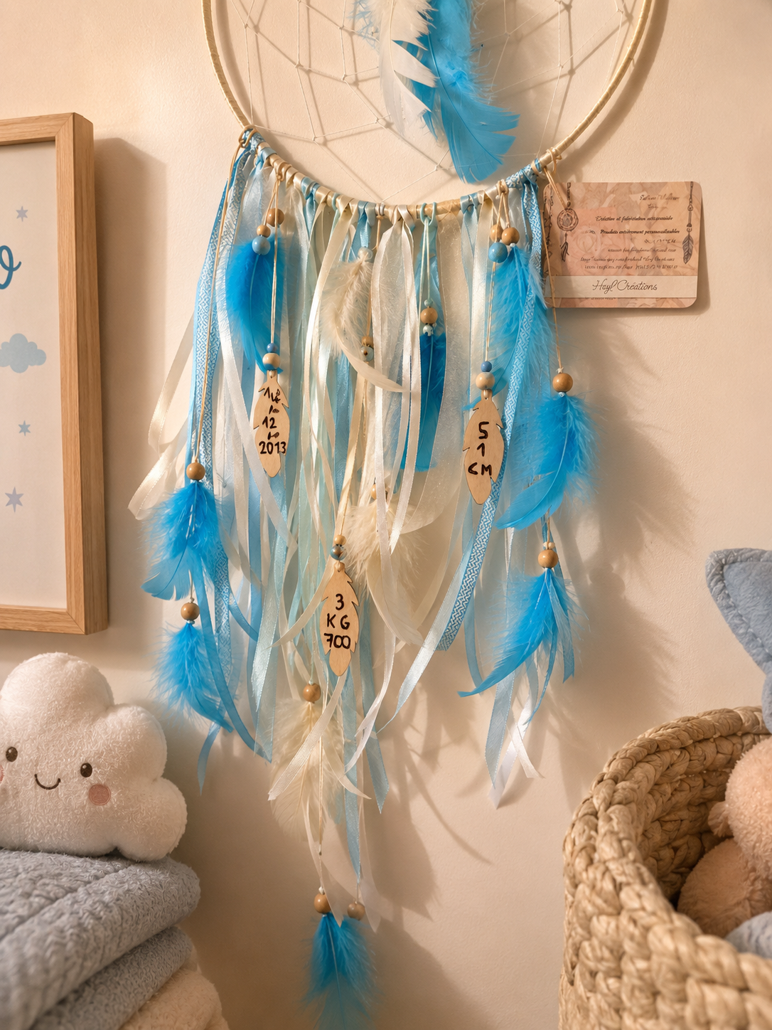 zoom sur le bas de l'attrape rêves avec les plumes en bois et les informations de naissance 